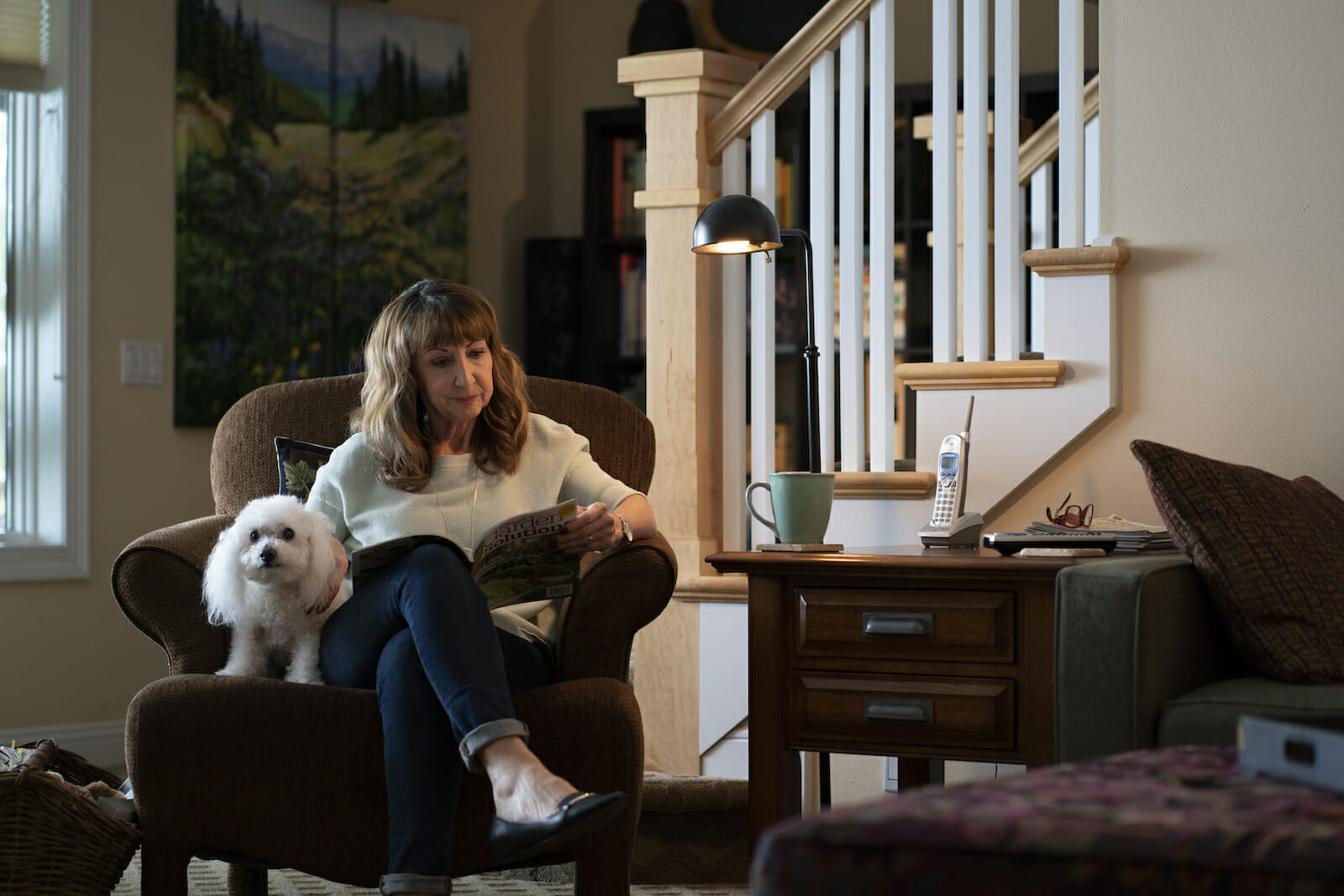 Woman reading book with dog.